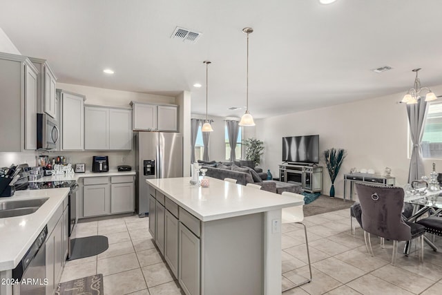 kitchen featuring gray cabinets, a center island, and stainless steel appliances