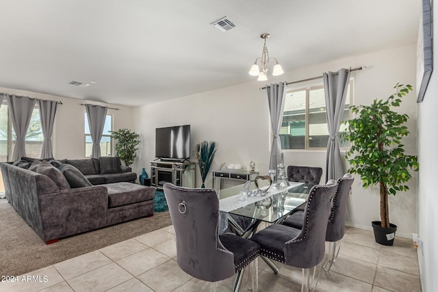 dining space with light tile patterned flooring and an inviting chandelier