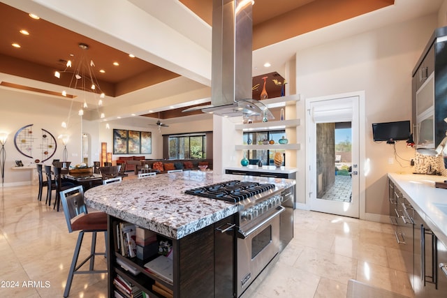 kitchen with plenty of natural light, a center island, stainless steel stove, and a kitchen breakfast bar