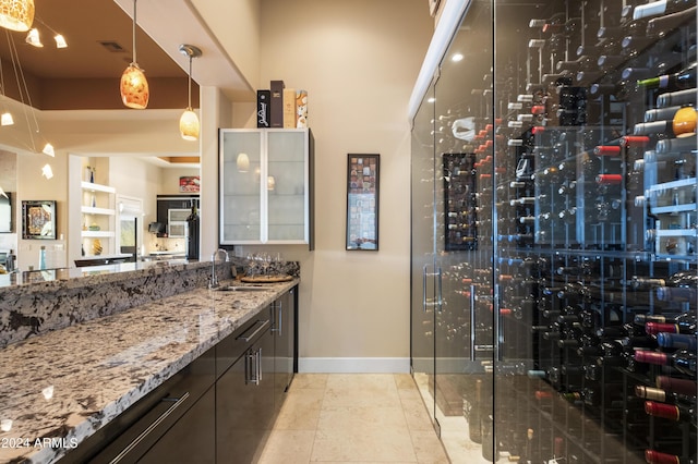 wine room featuring tile patterned flooring, visible vents, baseboards, electric panel, and a sink