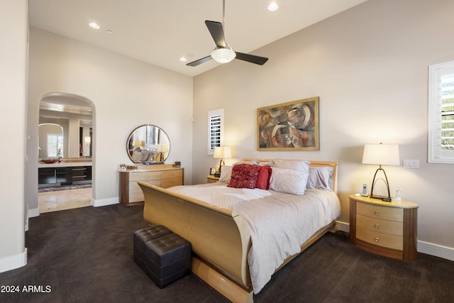 bedroom featuring baseboards, recessed lighting, arched walkways, a ceiling fan, and dark colored carpet