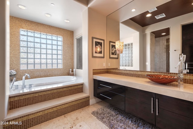 bathroom featuring vanity, tiled tub, and tile patterned floors