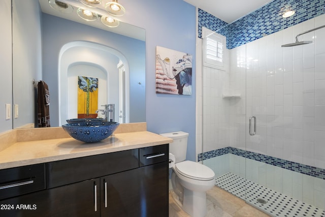 bathroom featuring vanity, tile patterned floors, toilet, and a stall shower