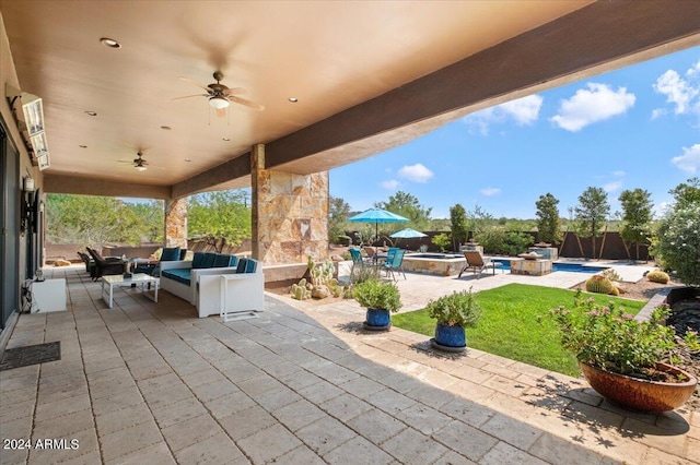 view of patio / terrace with outdoor lounge area, ceiling fan, and a pool with hot tub