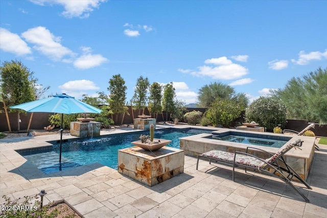 pool with a patio, an in ground hot tub, and fence