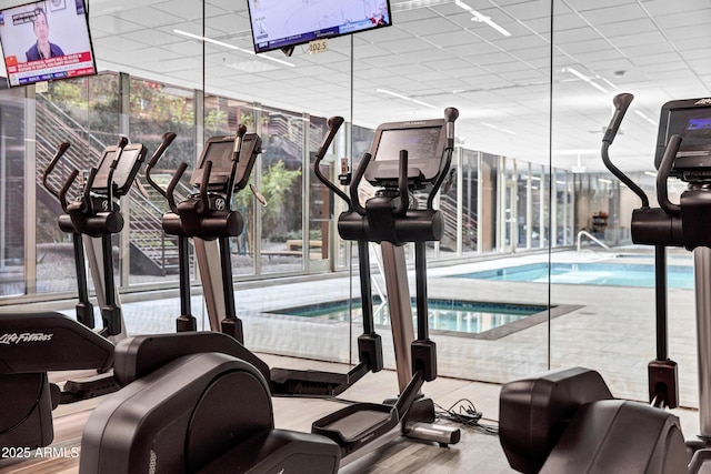 exercise room featuring a drop ceiling, a wealth of natural light, and floor to ceiling windows