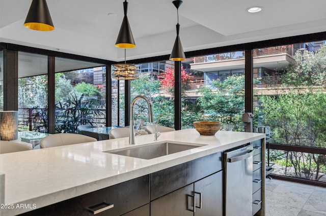 kitchen with a sink, a wealth of natural light, pendant lighting, and dishwasher