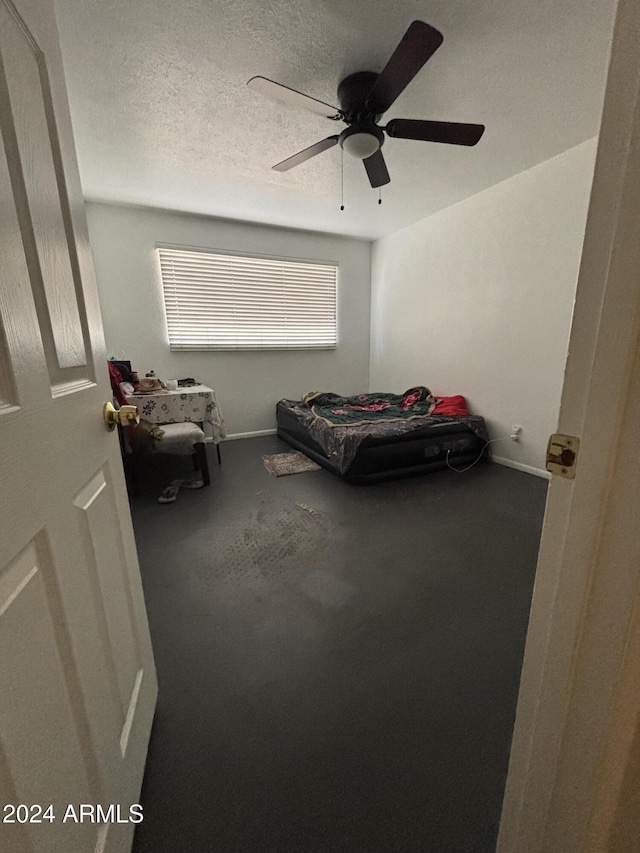 bedroom featuring ceiling fan, carpet floors, and a textured ceiling