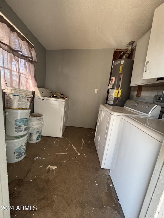 clothes washing area with cabinets, gas water heater, and independent washer and dryer