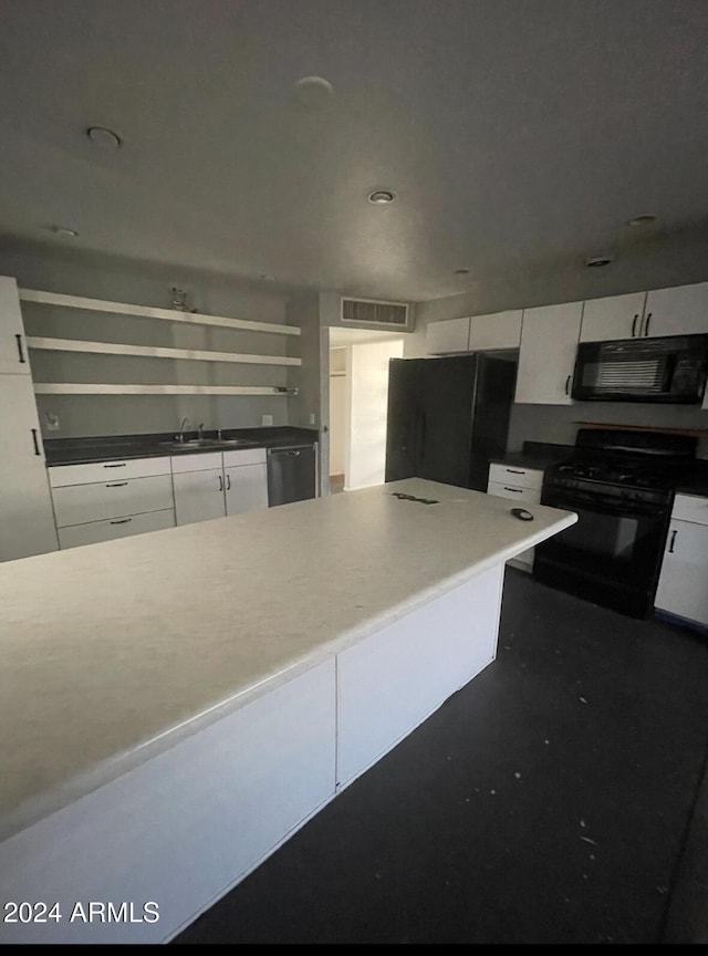 kitchen with black appliances, white cabinets, and sink