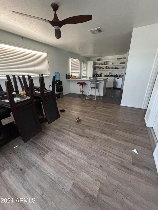 dining space featuring ceiling fan, wood-type flooring, and a textured ceiling