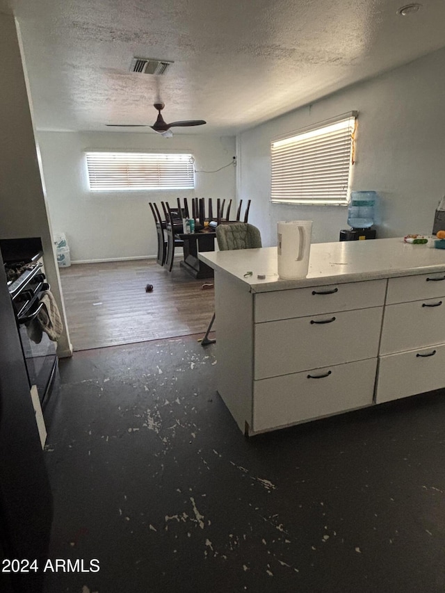 kitchen featuring dark hardwood / wood-style flooring, a textured ceiling, white cabinetry, and ceiling fan