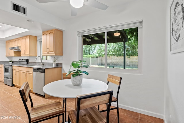 dining area with sink, light tile patterned floors, and ceiling fan