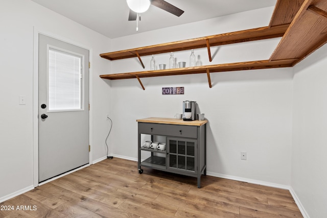 clothes washing area featuring ceiling fan and light wood-type flooring