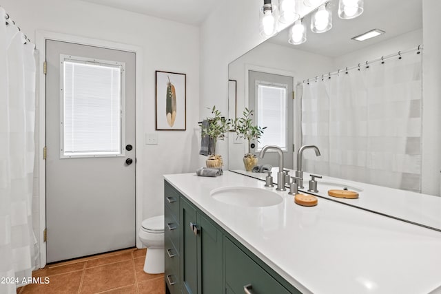 bathroom featuring vanity, a wealth of natural light, tile patterned floors, and toilet