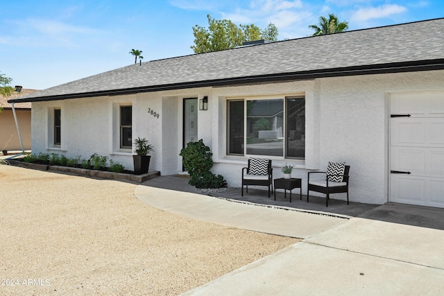 ranch-style home with a garage and a patio area