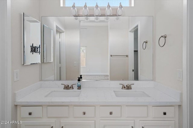 bathroom featuring double vanity and a healthy amount of sunlight