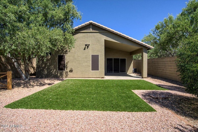 back of house with a patio area and a lawn