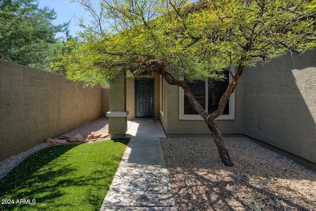 doorway to property with a lawn