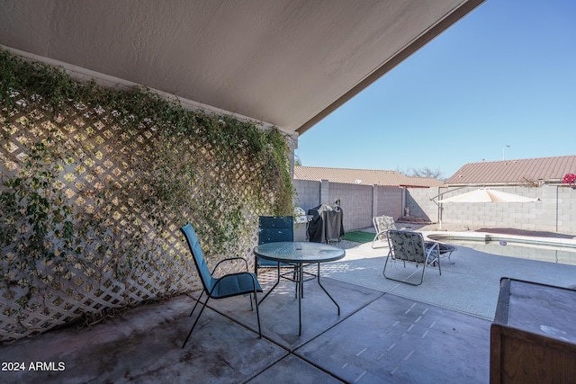 view of patio with a fenced in pool and area for grilling