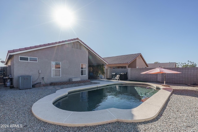 view of swimming pool featuring cooling unit and a patio area