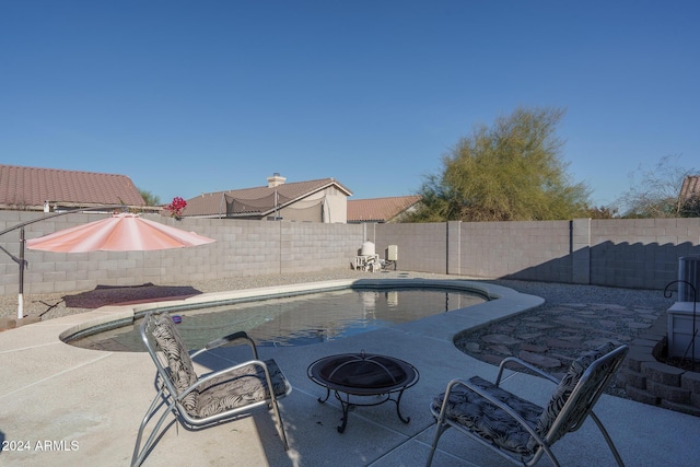 view of swimming pool featuring a patio and an outdoor fire pit