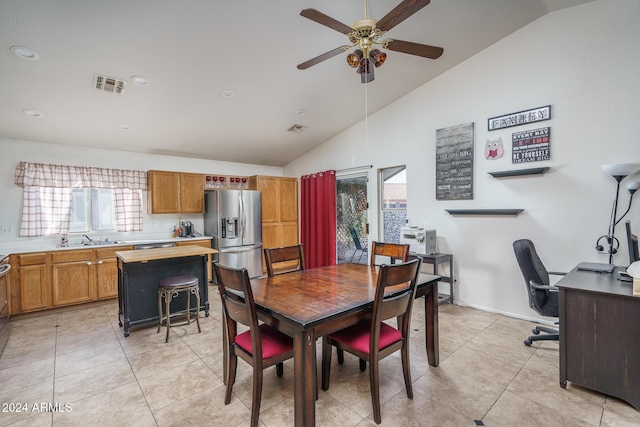 tiled dining space featuring vaulted ceiling, ceiling fan, and sink