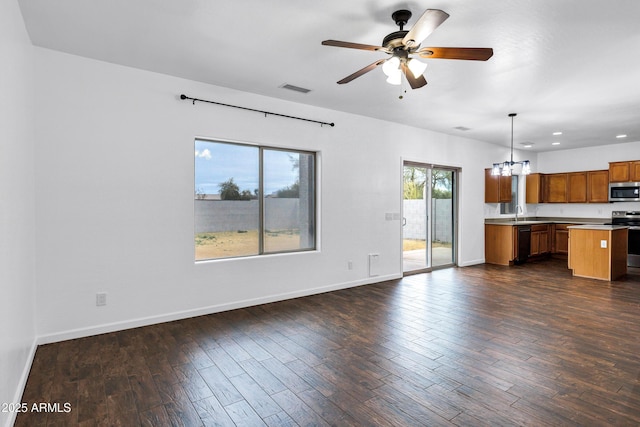 kitchen with dark hardwood / wood-style flooring, decorative light fixtures, ceiling fan with notable chandelier, and stainless steel appliances