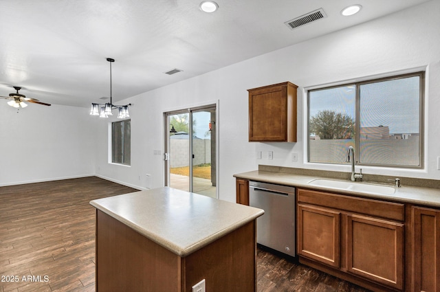 kitchen with a kitchen island, decorative light fixtures, dishwasher, sink, and dark hardwood / wood-style flooring