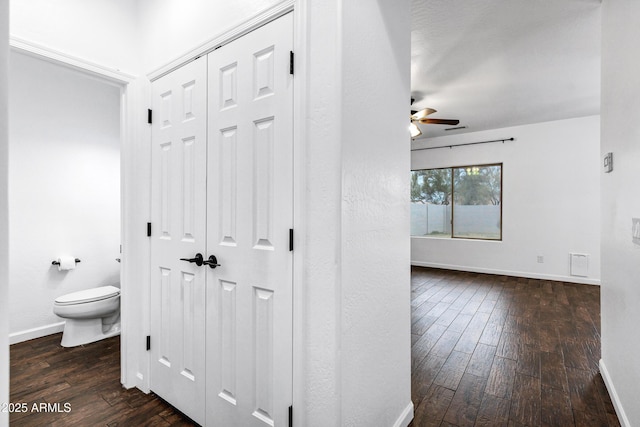 interior space featuring hardwood / wood-style flooring, ceiling fan, and toilet