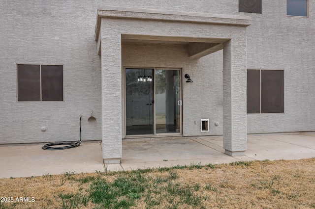 view of exterior entry with a patio