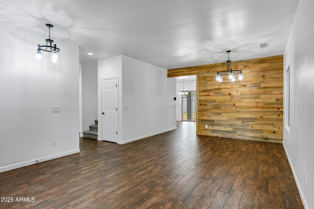 interior space featuring wooden walls, dark hardwood / wood-style floors, and a notable chandelier