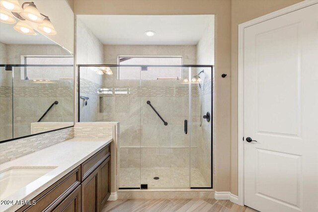 bathroom featuring hardwood / wood-style flooring, vanity, and an enclosed shower