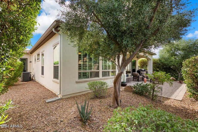 view of side of property with a patio and cooling unit