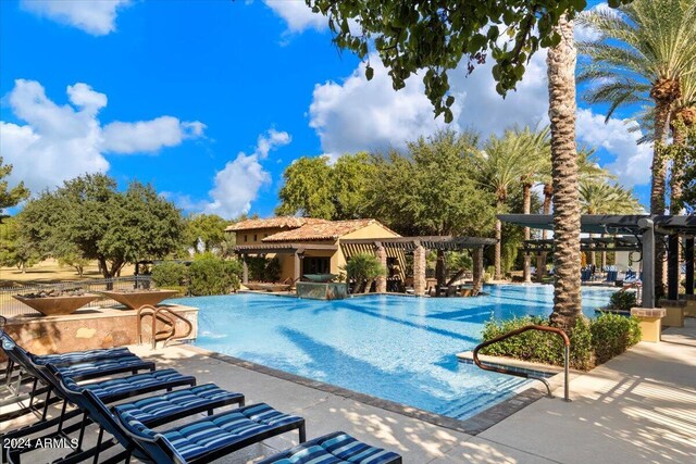 view of pool featuring a pergola, pool water feature, and a patio area