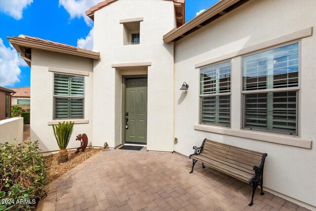 view of exterior entry with a patio area