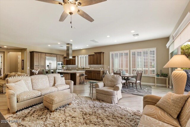 living room featuring light wood-type flooring and ceiling fan