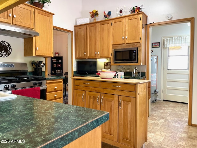 510 Tombstone Cyn, Bisbee, AZ 85603 - kitchen featuring stainless steel appliances, under cabinet range hood, gas water heater, dark countertops, and brown cabinetry