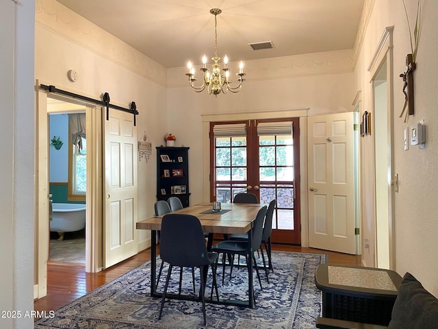 510 Tombstone Cyn, Bisbee, AZ 85603 - dining room featuring a chandelier, dark wood-style flooring, and a barn door