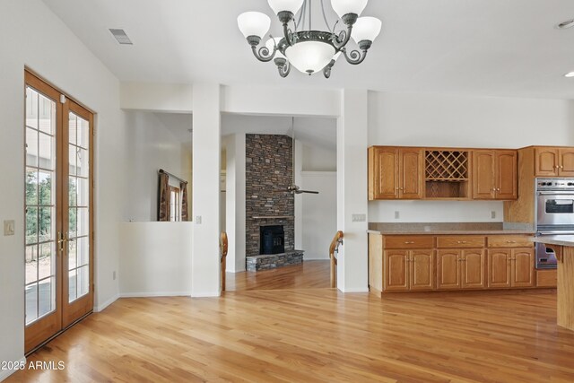 889 E Dealers Choice Ln, Payson, AZ 85541 - kitchen with a stone fireplace, open shelves, light countertops, double oven, and light wood finished floors
