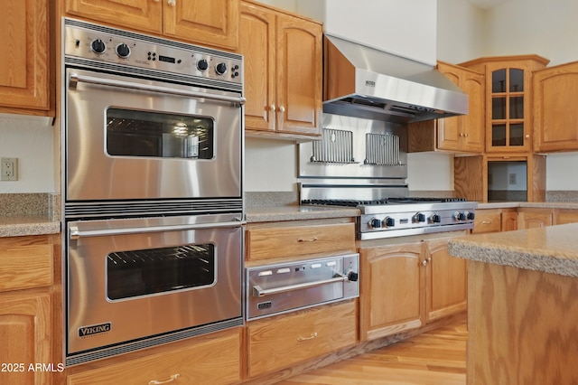 889 E Dealers Choice Ln, Payson, AZ 85541 - kitchen featuring light stone counters, light wood-style flooring, stainless steel appliances, glass insert cabinets, and a warming drawer