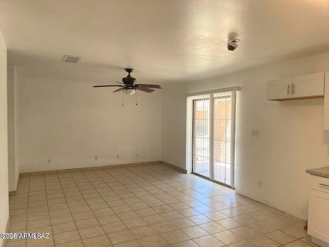 tiled empty room with ceiling fan