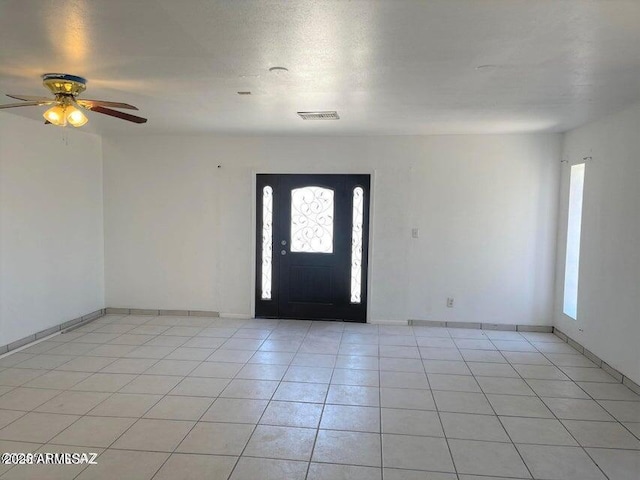 tiled foyer featuring ceiling fan