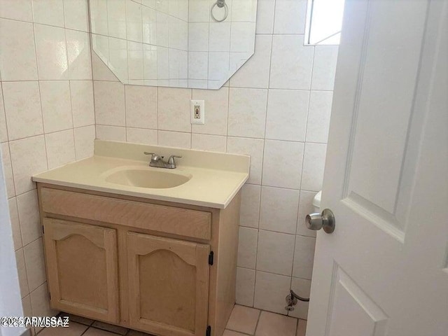 bathroom featuring tile patterned flooring, vanity, and tile walls