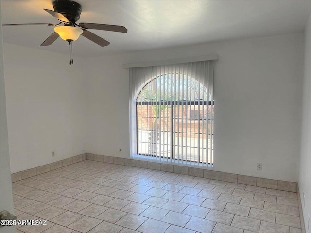 tiled spare room with ceiling fan