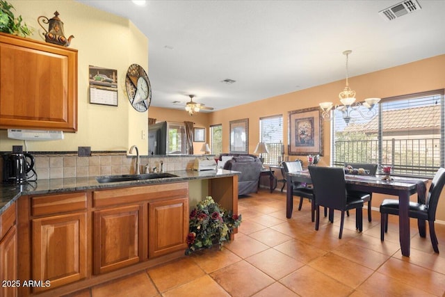 kitchen featuring light tile patterned floors, ceiling fan with notable chandelier, plenty of natural light, and sink