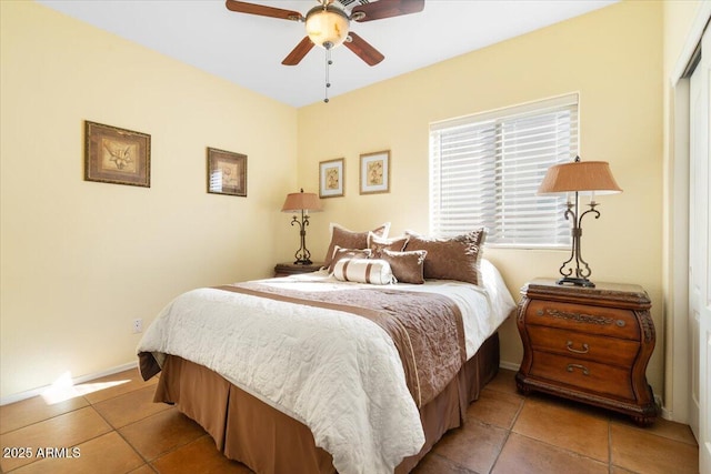 bedroom with light tile patterned floors, a closet, and ceiling fan