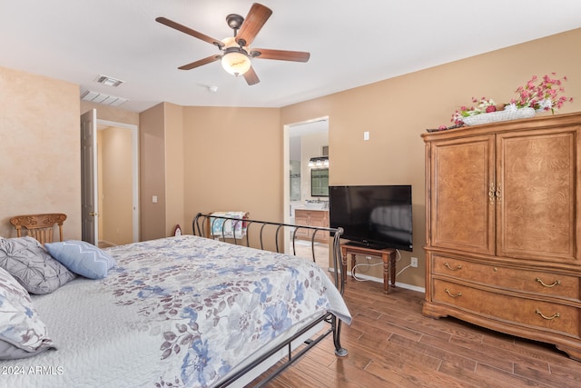 bedroom featuring ensuite bathroom, hardwood / wood-style floors, and ceiling fan