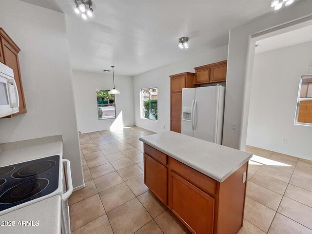 5339 W Maldonado Rd, Laveen, AZ 85339 - kitchen featuring white appliances, light tile patterned floors, light countertops, and brown cabinetry