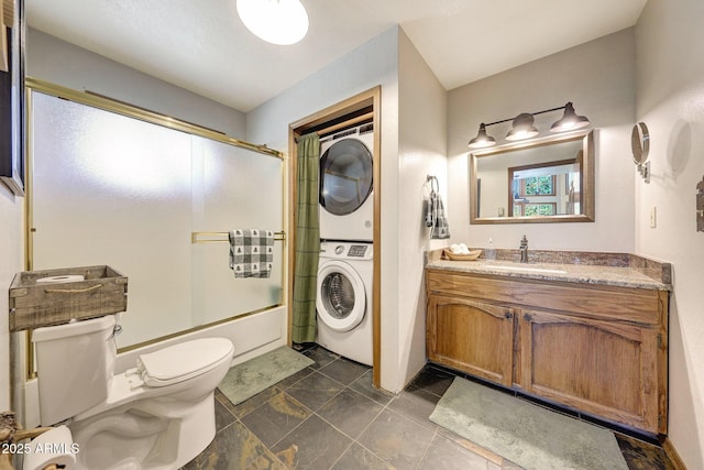 17425 Sequoia Dr, Munds Park, AZ 86017 - full bath with stacked washer and clothes dryer, toilet, shower / bath combination with glass door, and vanity